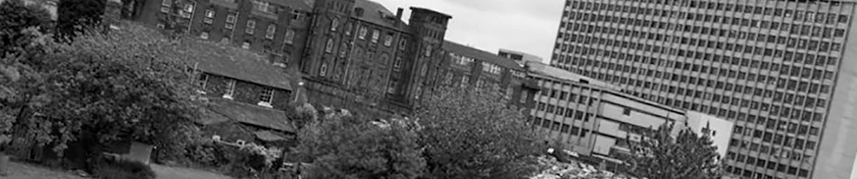 Black and white urban landscape with historic brick buildings, trees, and Hull Royal Infirmary